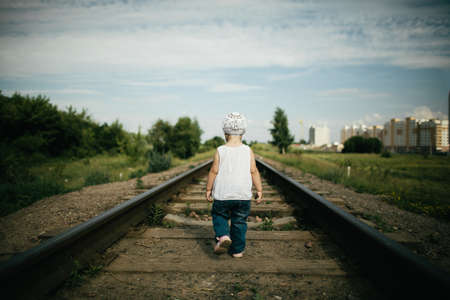 little beautiful girl plays on railroad photoの写真素材