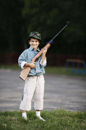 photo of little boy with airgun shooting outdoorsの写真素材