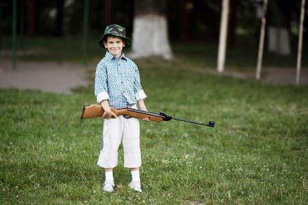 photo of little boy with airgun shooting outdoorsの写真素材