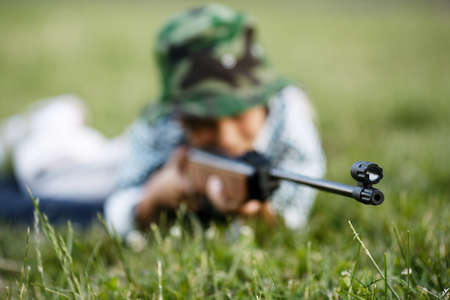 photo of little boy with airgun shooting outdoorsの写真素材