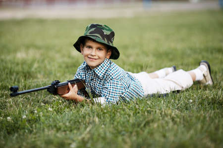 photo of little boy with airgun shooting outdoorsの写真素材