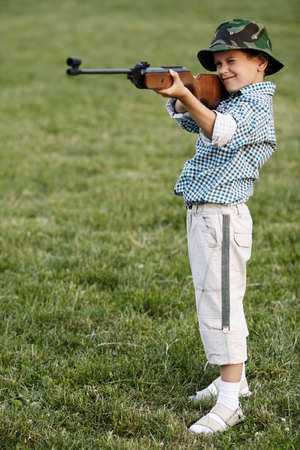 photo of little boy with airgun shooting outdoorsの写真素材