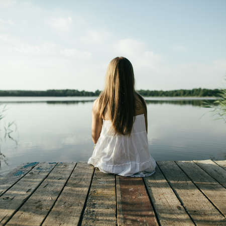 young beautiful girl on coast of lakeの写真素材