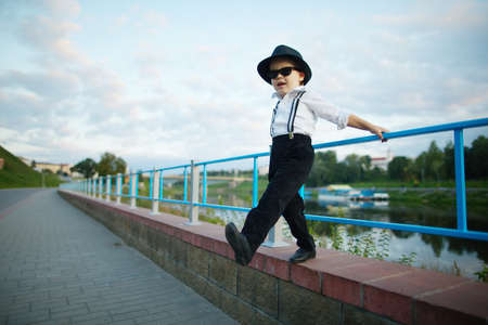 photo of little gentleman with sunglasses outdoors portrait