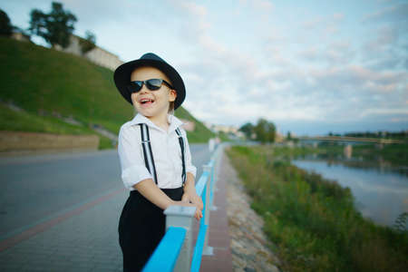 photo of little gentleman with sunglasses outdoors portrait