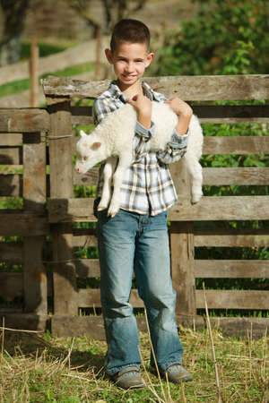 little boy with lamb on the farmの写真素材