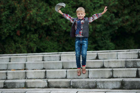 portrait of little boy jumping on the stairsの写真素材