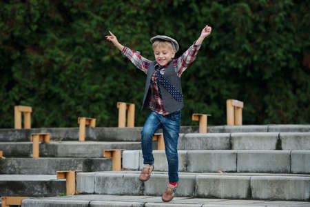 portrait of little boy jumping on the stairsの写真素材