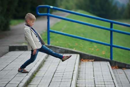 portrait of little boy jumping on the stairsの写真素材