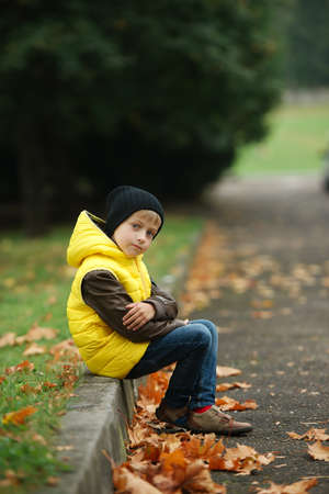 little funny boy in autumn leaves outdoor portraitの写真素材