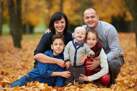 happy family in autumn park on yellow leaves