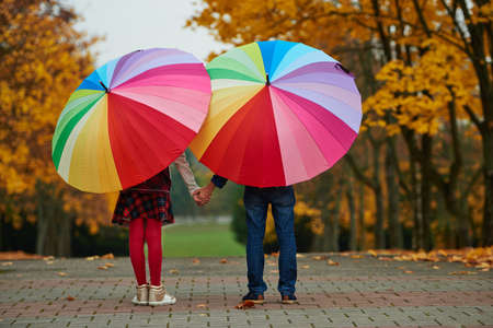 boy and girl among the leaves in autumn park