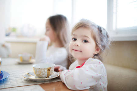 cute little girl drinks tea in the morningの写真素材