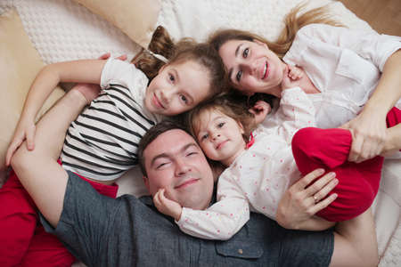 happy young family lying in bed at home