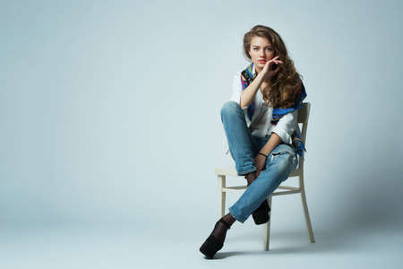 beautiful girl with long hair posing on chairの写真素材