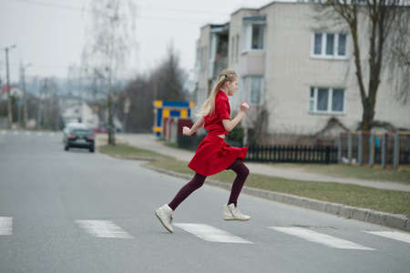 photo of girl crossing street on the crosswalkの写真素材