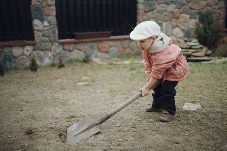 little boy digging a hole in the yardの写真素材