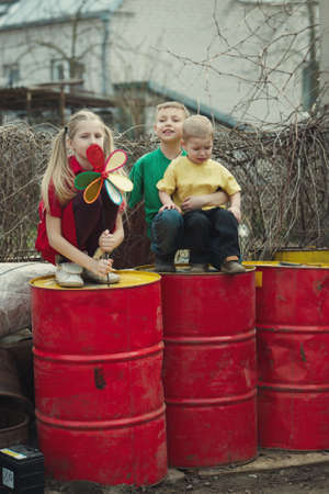 children play at dump drums of oilの写真素材