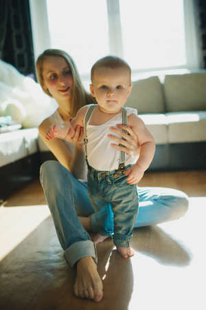 young beautiful mother with baby sitting on the floor