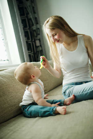 young mother feeding baby with a spoonの写真素材