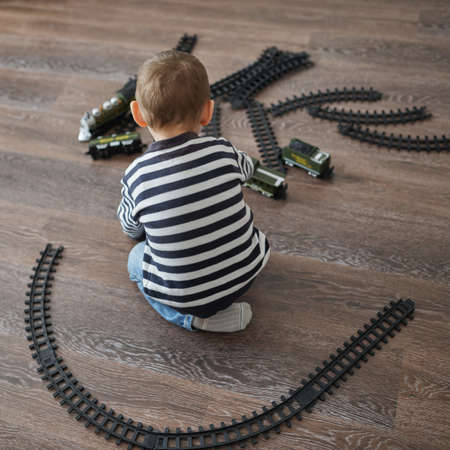 photo of little happy boy builds toy railroadの写真素材
