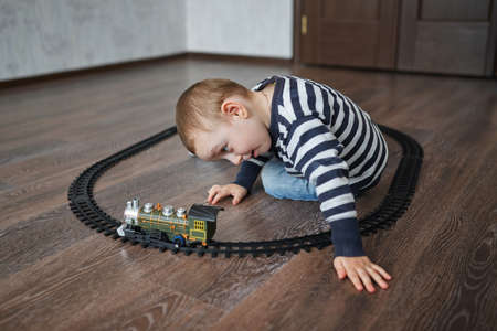 photo of little happy boy builds toy railroadの写真素材