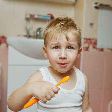 little boy learns to brush teeth with toothbrushの写真素材