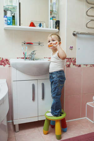 little boy learns to brush teeth with toothbrushの写真素材