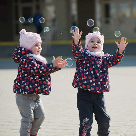 little girl plays with bubbles on playground
