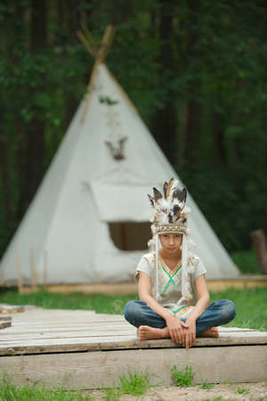 photo of little funny boy with native american costume