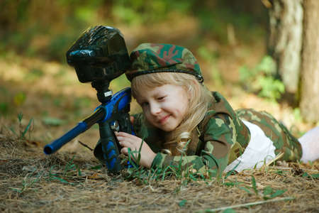 little girl in camouflage suit with rifleの写真素材