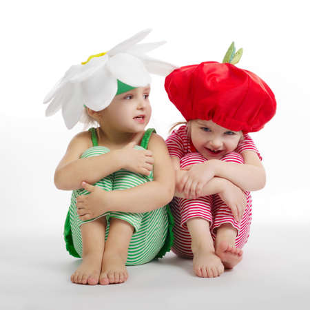 Two little girls with vegetation costumes on whiteの写真素材