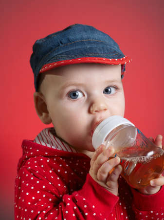 photo of little girl drinking juice from bottleの写真素材