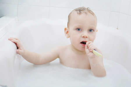 photo of little boy washing in bath