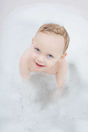 photo of little boy washing in bath