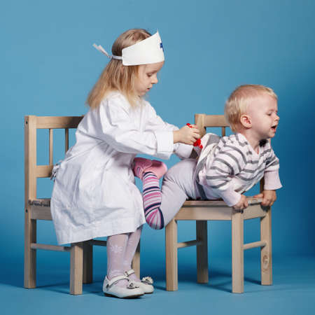 two cute little girls playing doctor. studio photoの写真素材
