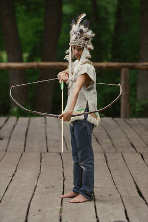 Photo of little funny boy playing native americanの写真素材