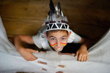 photo of little funny boy playing native americanの写真素材
