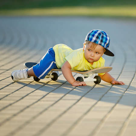 photo of cute little boy with skateboard outdoorsの写真素材