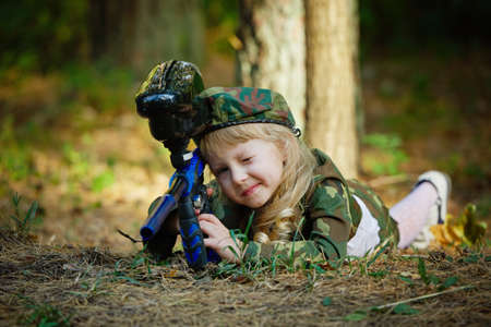 little girl in camouflage suit with rifleの写真素材