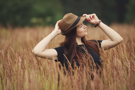 Young beautiful girl in high grass portraitの写真素材