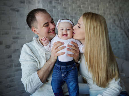 photo of happy father and mother with baby