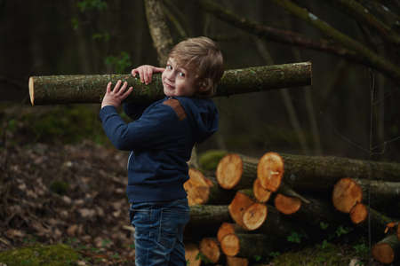 photo of little sweet lumberjack in autumn forestの写真素材