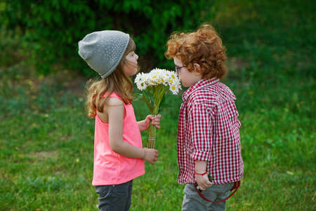 photo of two cute hipsters smell the flowersの写真素材