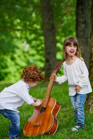photo of cute little children playing guitarの写真素材