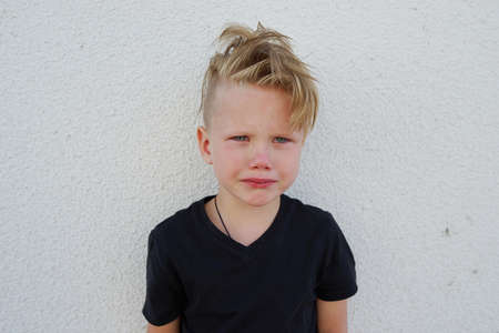 photo of young emotional boy on bright backgroundの写真素材