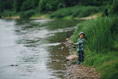 little happy boy fishing on the coast of riverの写真素材