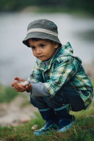 little happy boy fishing on the coast of riverの写真素材