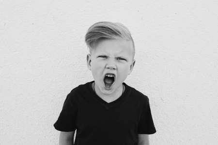 photo of young emotional boy on bright backgroundの写真素材