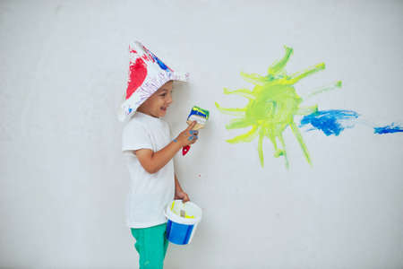 photo of little happy boy with colorful brushの写真素材